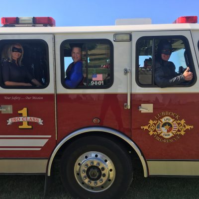 Lubbock batman, Superman, and catwoman in a Lubbock firetruck